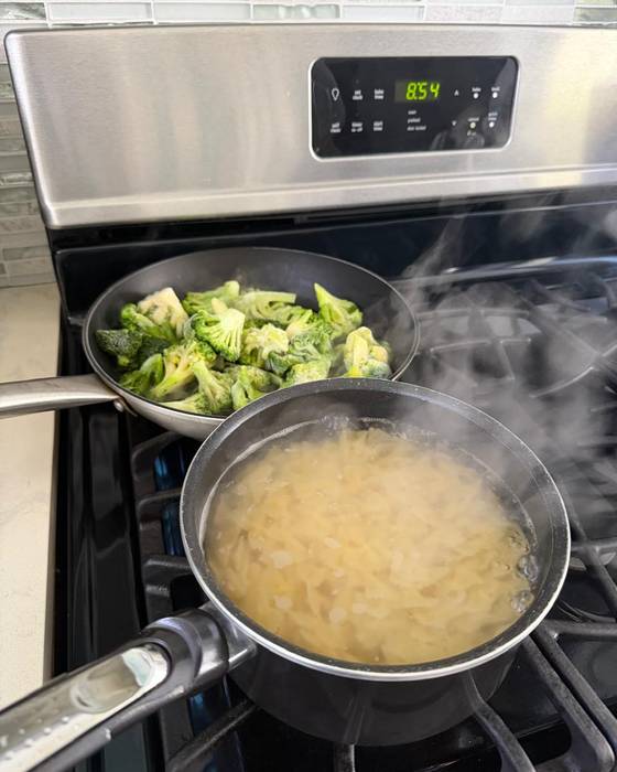 Vegetables cooking in a pan on the hob.