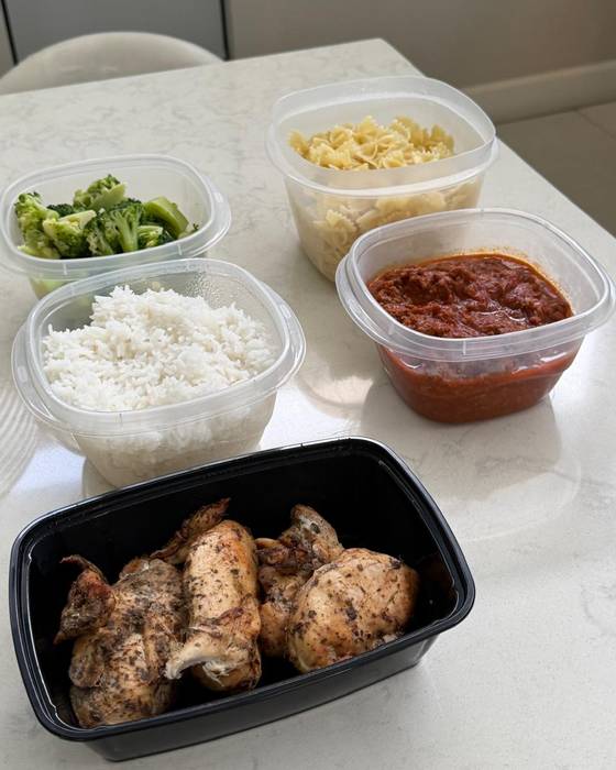 Containers of rice, broccoli, sauce and cooked chicken ready for the week.