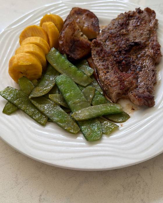 Steak with fried plantain and mangetout.